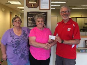 Nancy Kelly along with Barb Barringer from the Friends of the Library, present a $500 check to Village President Mike Newman for new Playground Equipment at the Bruce Park. 